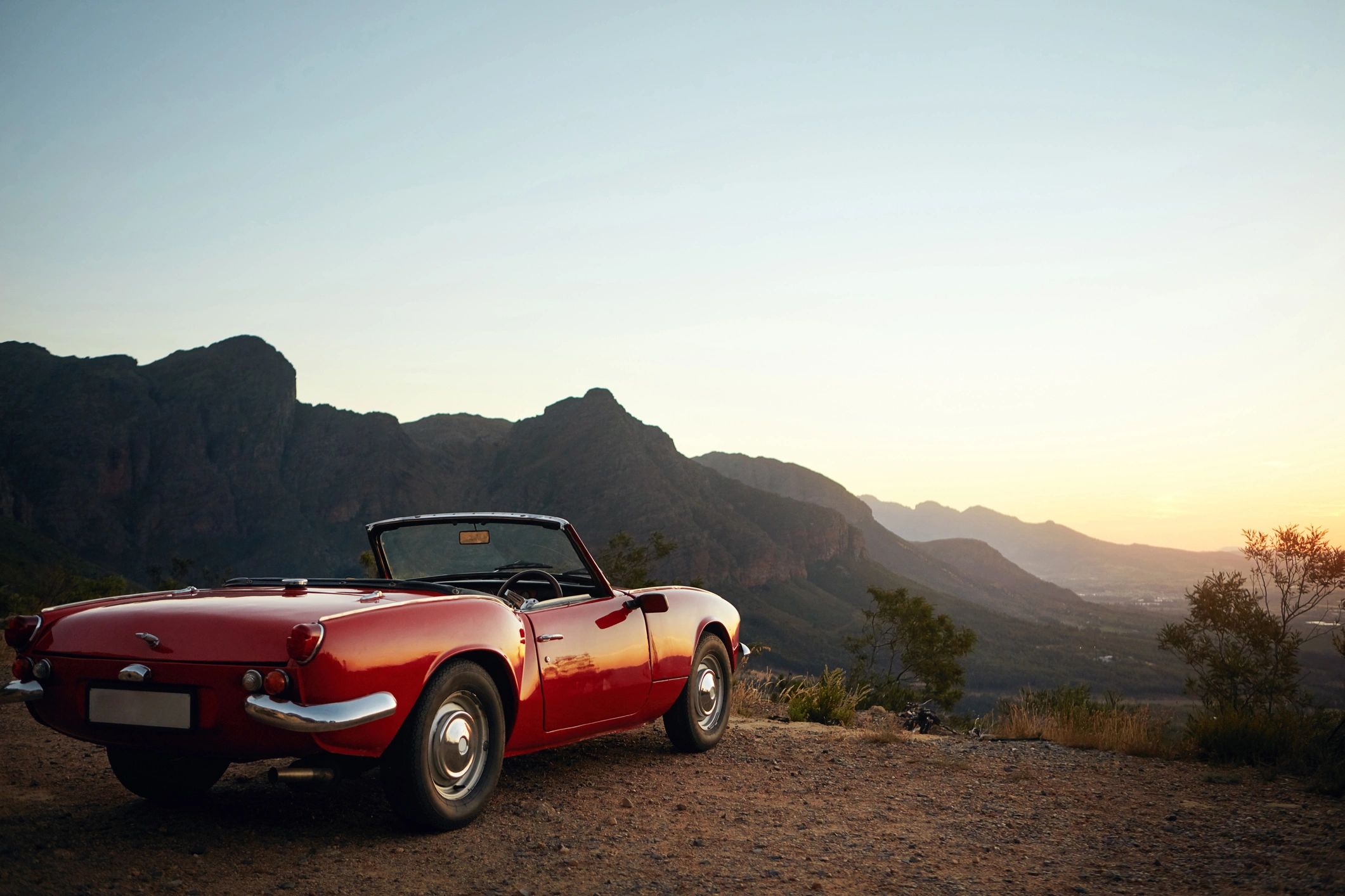 Vintage car parked by a mountain road