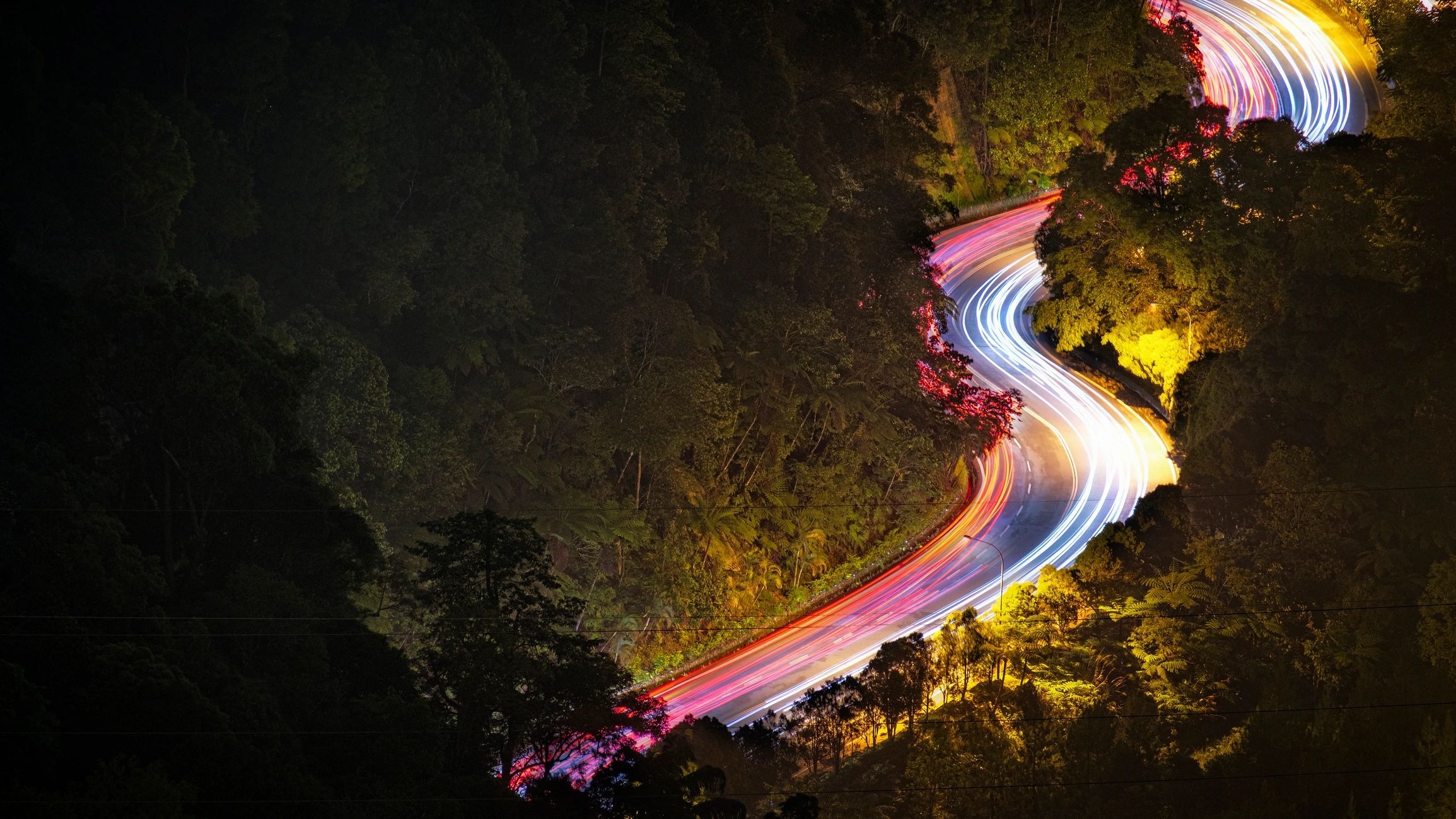 Light trails on a hillside road at night
