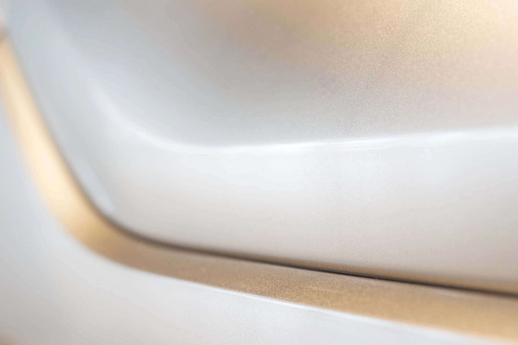 Close-up of a sleek metallic surface with soft curves and gradient light